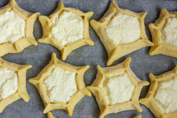 a circle of dough with cottage cheese filling on the table, cooking cheesecakes with cottage cheese
