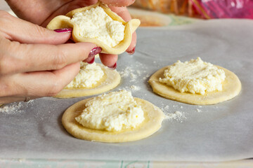 woman's hands sculpt curd cheesecakes. The process of making pie dough by hand