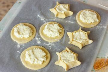 a circle of dough with cottage cheese filling on the table, cooking cheesecakes with cottage cheese
