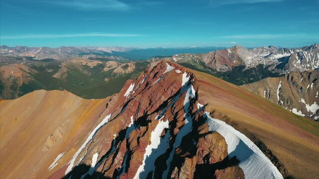 Aerial footage over snow frosted mountain peaks. 