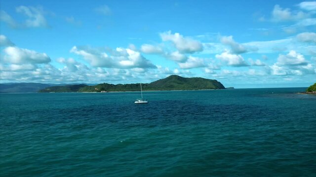 Drone tracks Catamaran in exotic island destination. 