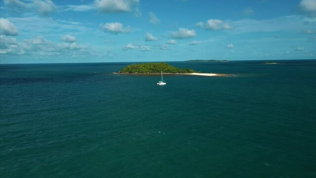 Drone tracks Catamaran in exotic island destination. 