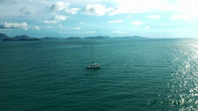 Drone tracks Catamaran in exotic island destination. 