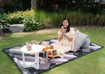 happy Asian woman enjoy picnic in fresh green garden, picnic net with snack and pillow, relax on vacation