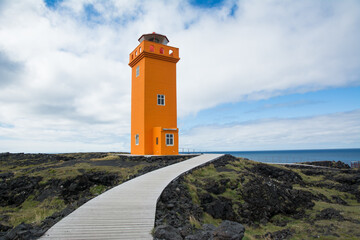 Bright orange lighthouse on the coast