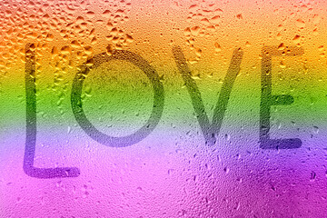 The inscription on the sweaty glass. The word LOVE written on glass with rainbow