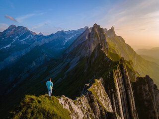 Schaefler mountain ridge swiss Alpstein, Appenzell Switzerland, steep ridge of the majestic Schaefler peak, Switzerland. couple man and woman mid age in the mountains, man hiking looking forward