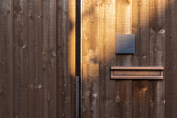 家の板塀に取り付けられた表札と郵便受け