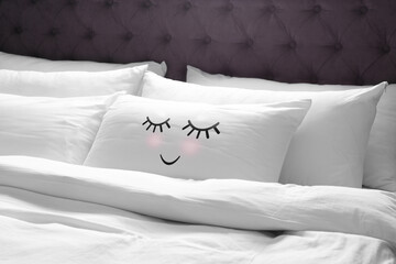 Soft pillow with cute face on comfortable bed