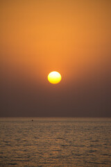 Big yellow sun setting over the ocean. No people, space for copy. Dhukan, Qatar.