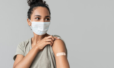 Woman showing her arm with bandage after receiving covid vaccination. Corona virus protection, self...