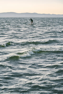 Man On Sup Board Paddling Far Away