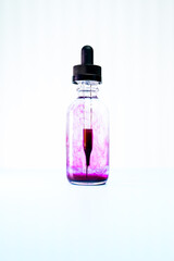 glass flask with purple paint on white background