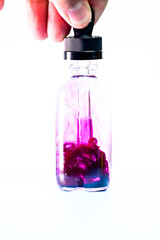 glass flask with purple paint on white background