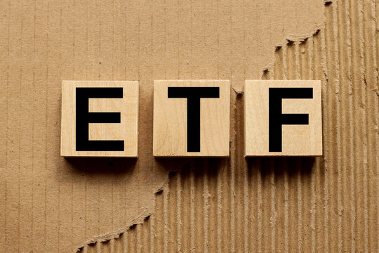 ETF (Exchange Traded Fund). wooden blocks on craft background from torn paper