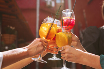 A group of friends cheers their drinks together, celebrating birthday. - obrazy, fototapety, plakaty