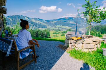 Switzerland countryside, Ebnat Kappel, Sankt-Gallen, Switzerland. woman cooking outside there tinny...