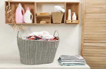 Fototapeta na wymiar Wicker basket with dirty laundry on white table in bathroom