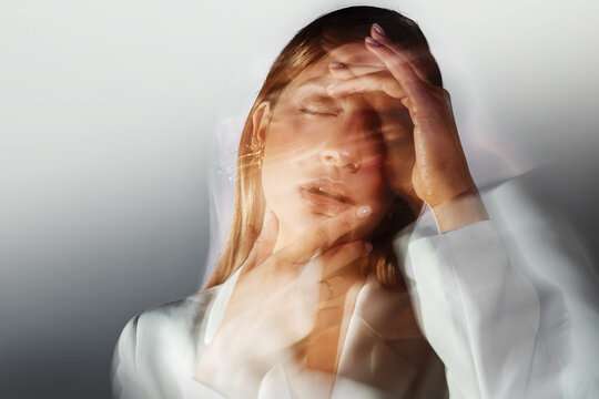 Headaches and mental health, concept. A young stylish woman in a white jacket,