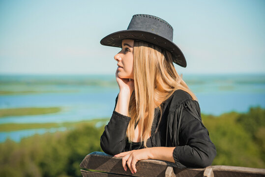 Girl In American Country Style Black Boho Jacket With A Fringe And Cowboy Hat At Nature