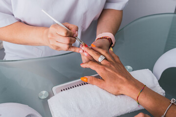 Beautician performing nails painted in a beauty salon