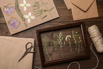 Flat lay composition with dried flowers and plants on wooden table