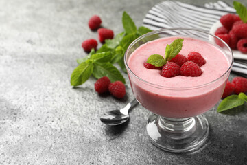 Delicious raspberry mousse with mint on grey table, space for text