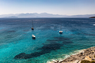 panoramic view of the sea and mountains and ships on turquoise water filmed from a drone