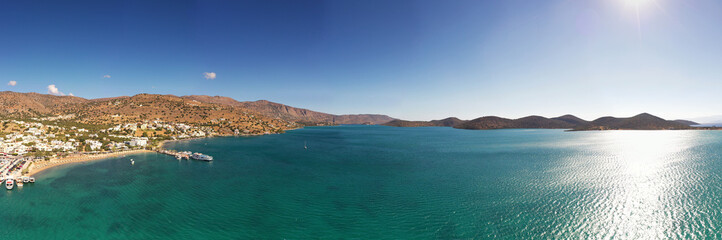 panoramic view of the sea and mountains and ships on turquoise water filmed from a drone