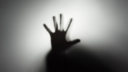 Silhouette of a man's hand behind a translucent glass. The concept of the other world, victims of...