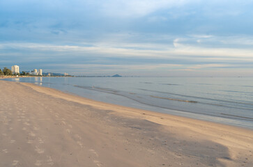 Obraz premium Early morning view of the serene Hua Hin Beach in Thailand, with its calm waters and soft sandy shore, under a pastel-colored sky. 