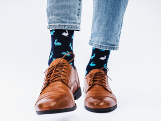 Men's legs, trendy shoes and bright socks. Close-up, indoors. Style, beauty and elegance concept