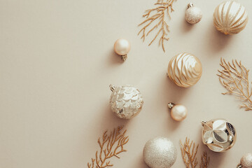 Christmas golden balls decorations on beige background. Xmas banner mockup with copy space. Flat lay, top view.