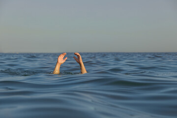 Drowning man reaching for help in sea