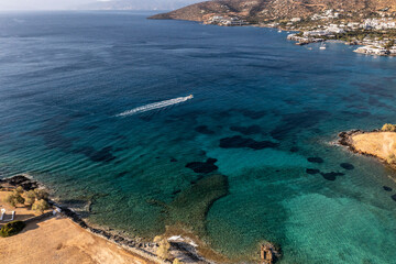 panoramic view of the sea and mountains and a boat on turquoise water filmed from a drone 