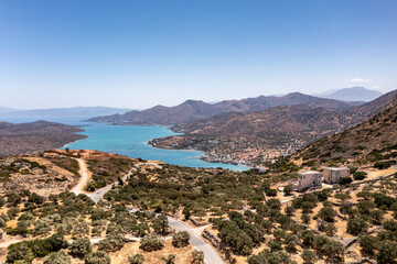 a panoramic view of the ancient centuries-old mills against the backdrop of mountains and olive groves of Crete filmed from a drone 