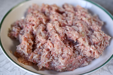 Step by step instructions. Step three. How to make a puff pastry product with meat at home. Stir the minced meat and onion. Ready minced meat on a plate. Shallow depth of field, soft focus.