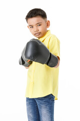 Cutout portrait of healthy Asian boy on yellow shirt wearing black boxing gloves, confidently standing and ready to fight with high intension and strong effort to win sport or game competition