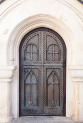 Fototapeta na wymiar Arched metal doors of the church with carvings. Forged gates of the monastery.
