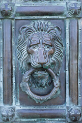 Decorative element. A door handle in the shape of a lion's head that holds a ring in its teeth.