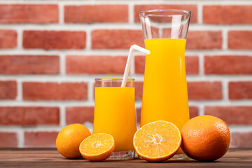 Fresh orange juice in jar and glass decorating with fresh orange on white wooden table. Studio picture concept for healthy diet