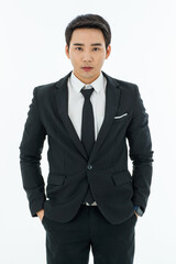Business man short hair wearing white shirt, tie suit pant are in black. His hands in pant pocket. Eyes concentrate to camera standing by white background. Looks smartstyle. Successful entrepreneur.