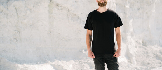 Hipster handsome male model with beard wearing black blank t-shirt with space for your logo or design in casual urban style - 453446761