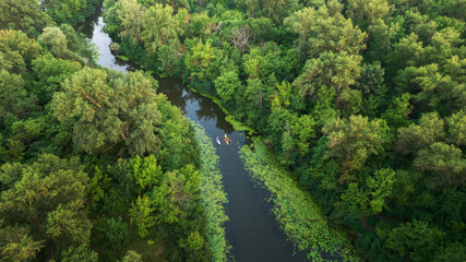 Fototapeta na wymiar Aerial view of scenic small river with green forested banks. Bobrovnia, a distributary of Desna River is perfect place for calm kayaking, canoeing and SUP boarding within the Kyiv city limits, Ukraine