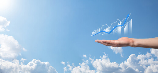 Business man holding tablet and showing holographic graphs and stock market statistics gain profits. Concept of growth planning and business strategy. Display of good economy form digital screen.