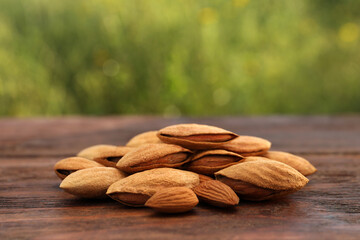 Almonds on wooden table outdoors, closeup view