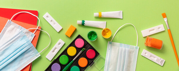 Fototapeta premium Back to school Covid 19 days. School supplies and Coronavirus measures flat lay. Rapid test, protective medical mask and stationery on blue background