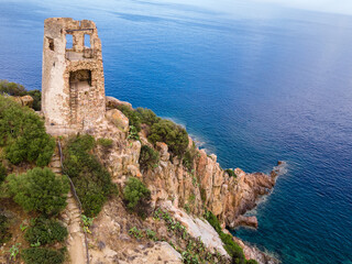 Fototapeta na wymiar San Gemiliano tower on the rocky coast on the blue sea. Sardinia, Italy. City of Arbatax.