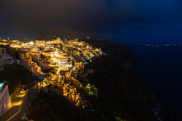 Obraz premium ギリシャ サントリーニ島の断崖の上にあるライトアップされたフィラの街の夜景