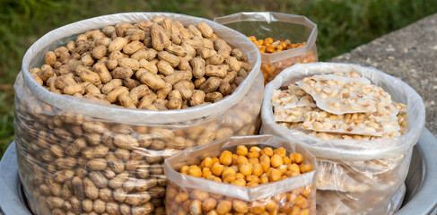 Candied roasted nuts, peanuts, fried pea, and snacks on a bowl close up
